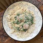 Lamb and spinach whole spice curry in a white bowl with rice
