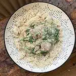 Lamb and spinach whole spice curry in a white bowl with rice
