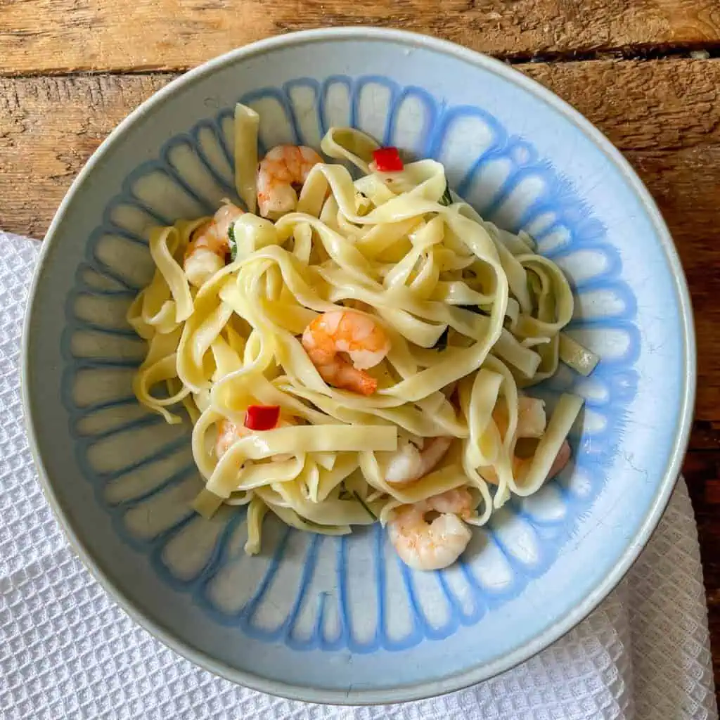 garlic chilli prawn pasta top view in a blue bowl