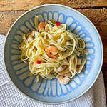 garlic chilli prawn pasta top view in a blue bowl