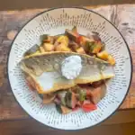 Tomato and courgette ratatouille with golden sea bass and soft goat’s cheese – vibrant and easy Mediterranean-style recipe.