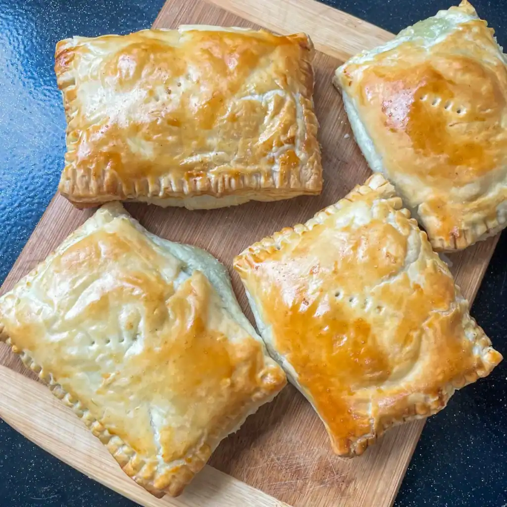 spinach and brie puff pastry parcels on a board
