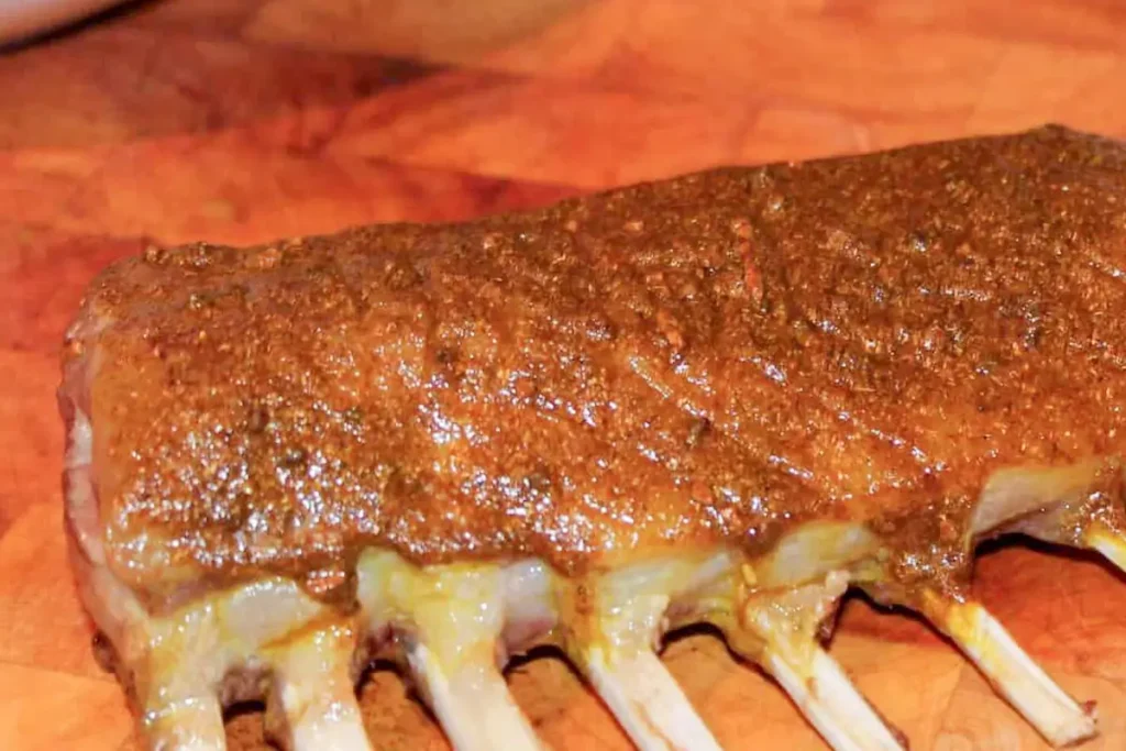 Curried rack of lamb with pilau rice and yoghurt-cucumber served on a plate