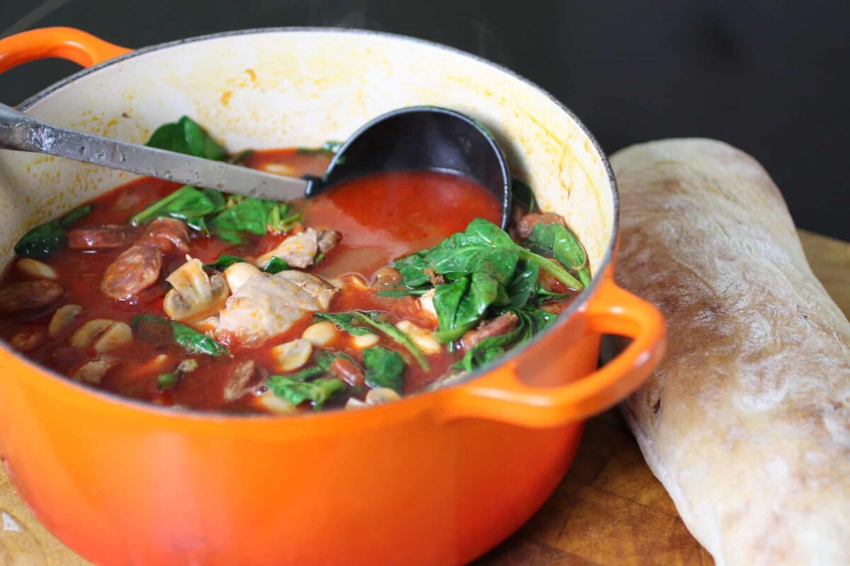 rustic chicken and chorizo stew with butter beans served in a deep bowl with crusty bread on the side