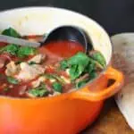 rustic chicken and chorizo stew with butter beans served in a deep bowl with crusty bread on the side