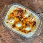 Anglesey eggs (boiled eggs and leeks cooked in a cheese sauce) in a glass oven dish