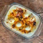 Anglesey eggs (boiled eggs and leeks cooked in a cheese sauce) in a glass oven dish