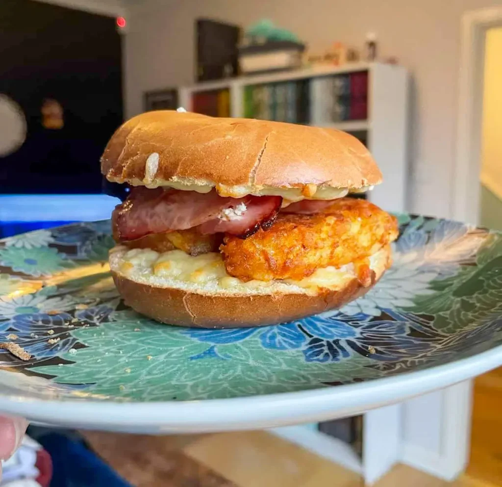Cross-section of best breakfast bagel showing bacon, hash brown and cheese layers