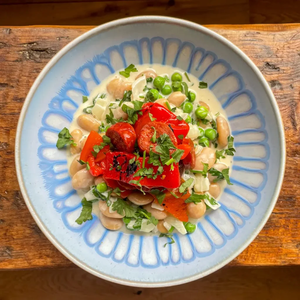 Creamy beans with chorizo in a blue bowl
