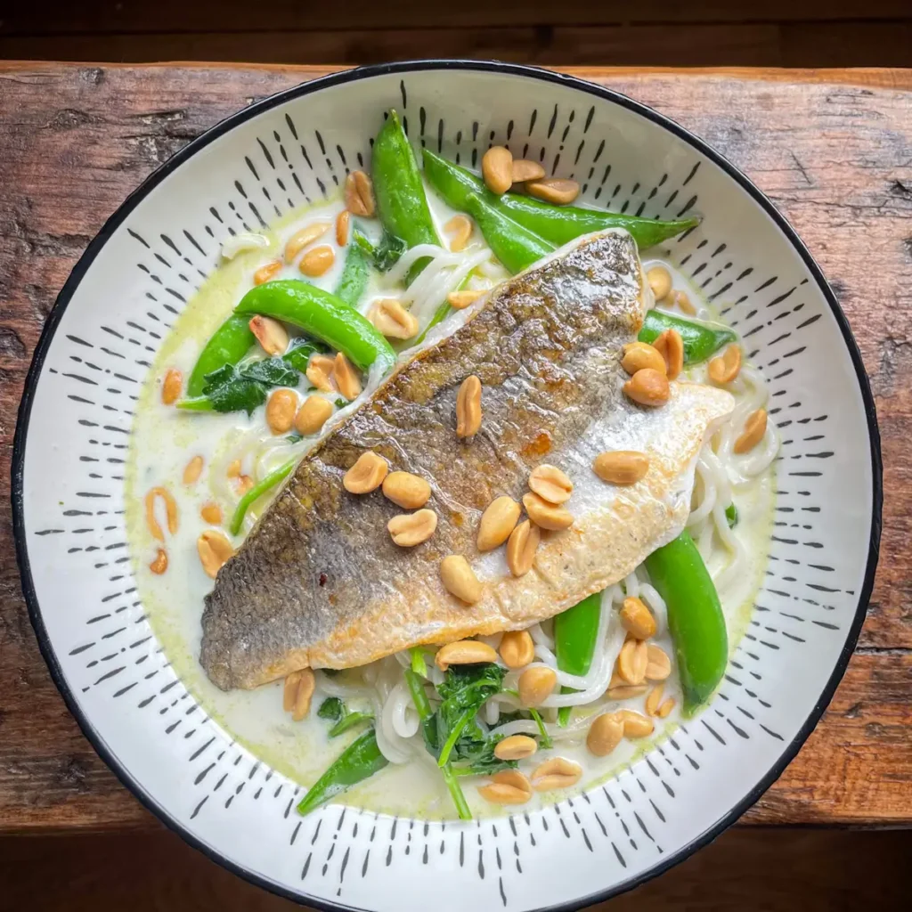 creamy Thai noodle soup topped with crispy fried sea bass