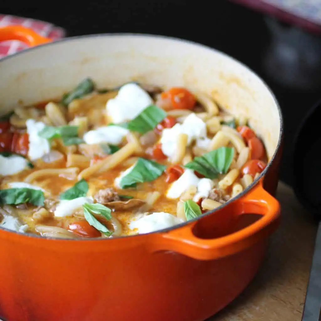 one pot sausage and mozzarella pasta in an orange casserole dish