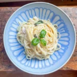 Feta and fennel pasta in a blue bowl on a wooden surface