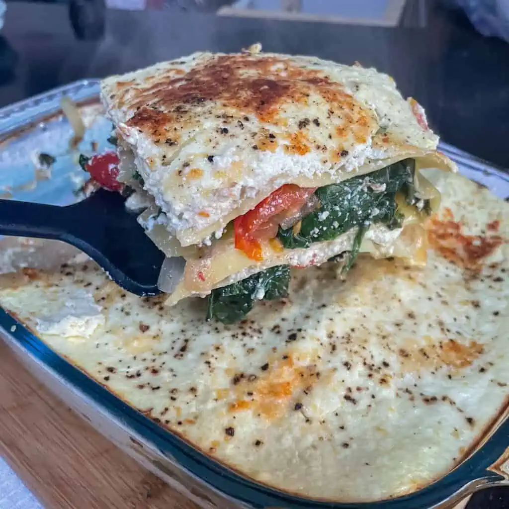 A sliced spinach and ricotta lasagne showing the creamy inside