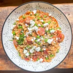 Top view of chorizo and pea pearl barley risotto topped with crumbled feta