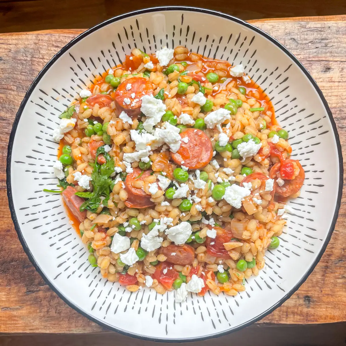 Top view of chorizo and pea pearl barley risotto topped with crumbled feta