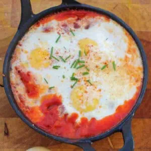top view of smoked paprika baked eggs topped with chopped chives