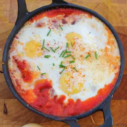 top view of smoked paprika baked eggs topped with chopped chives