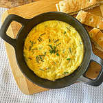 feta baked eggs in a black cast iron top view with bread on the side
