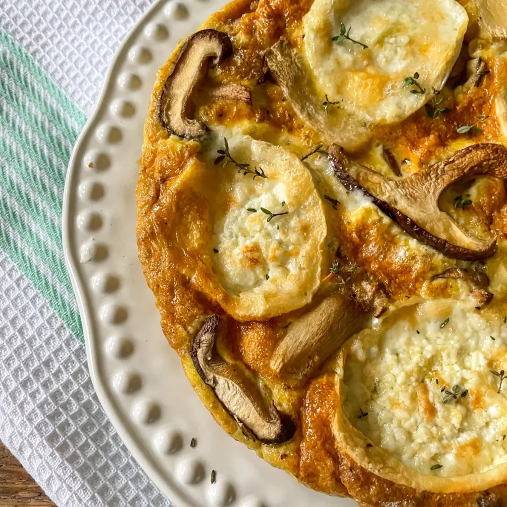 Close up of a mushroom and goats cheese frittata on a white plate