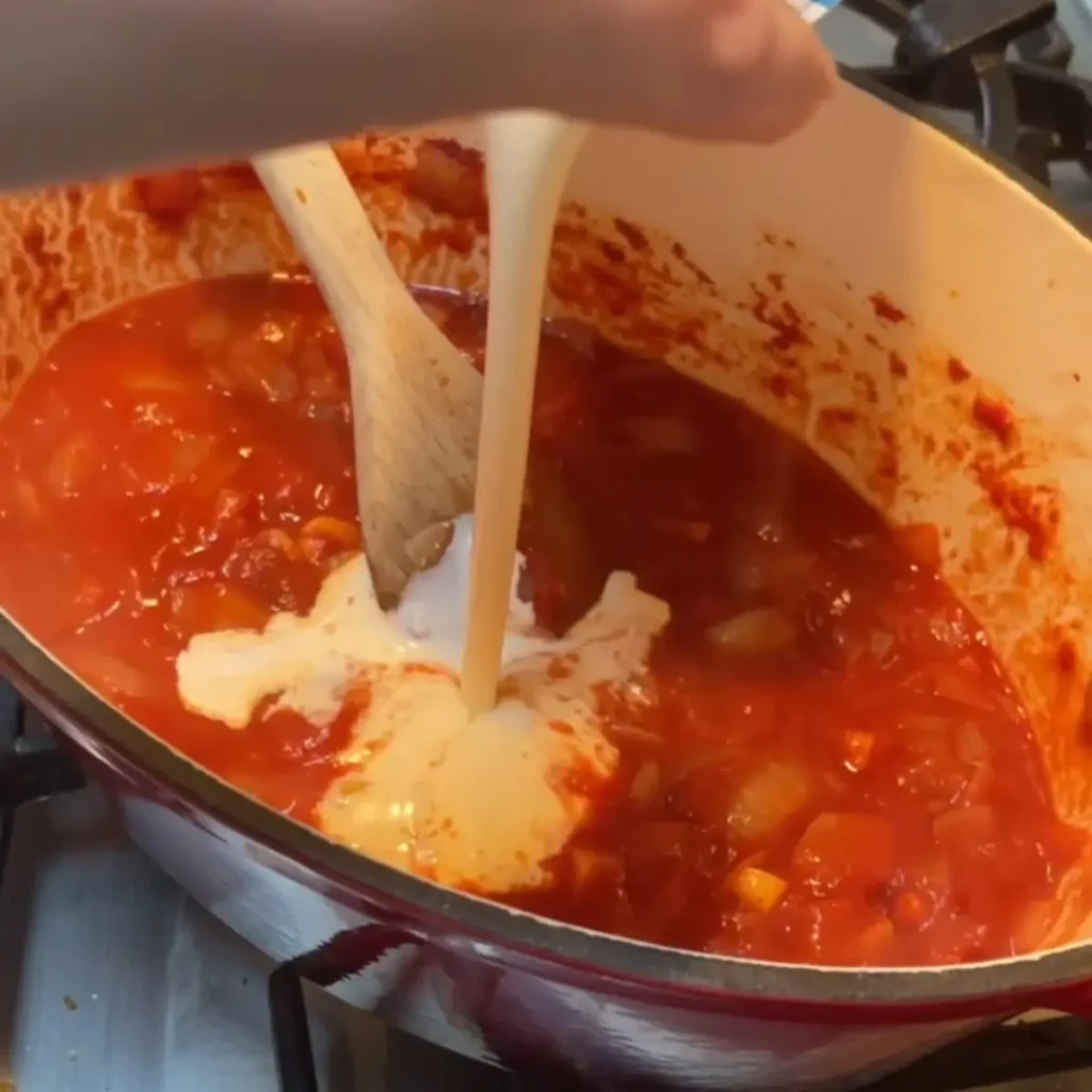 Butter halloumi curry process shot 3 - adding cream to the curry sauce