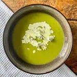 Three-cornered leek soup Top view with flowers and cream