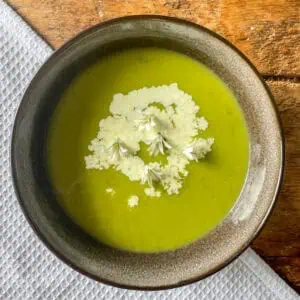 Three-cornered leek soup Top view with flowers and cream