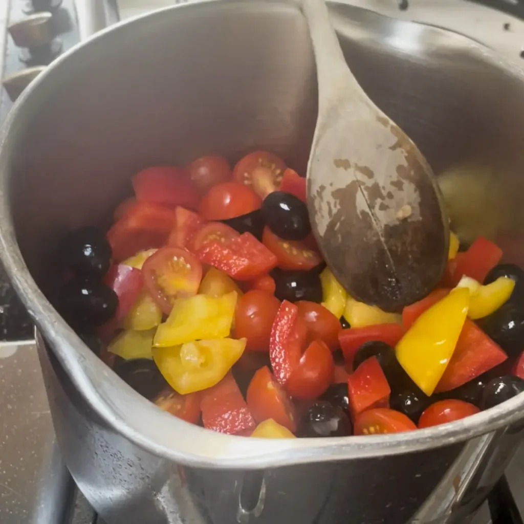 Process shot 1 - cooking the tomatoes peppers and olives