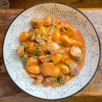 creamy gnocchi with sausages and mushrooms in a white bowl