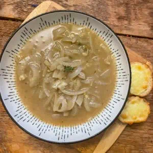 A vegetarian onion soup with cheesy croutons on the side