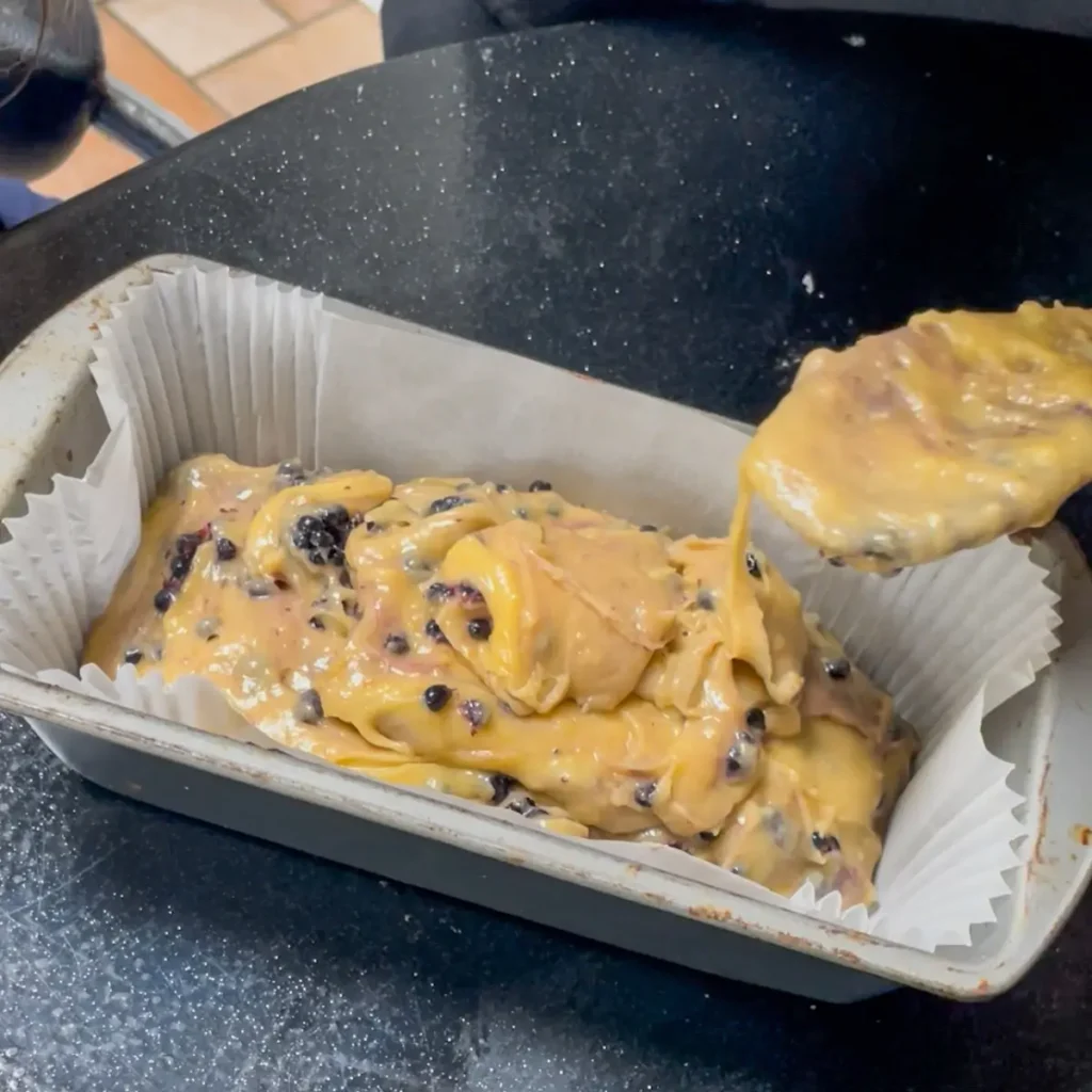 Blackberry loaf cake process shot 5 - tipping the cake mix into a loaf tin