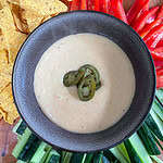 Nacho cheese sauce Surrounded by cucumber peppers and nachos