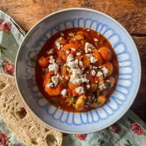 Prawn saganaki In a blue and white bowl on a wooden table