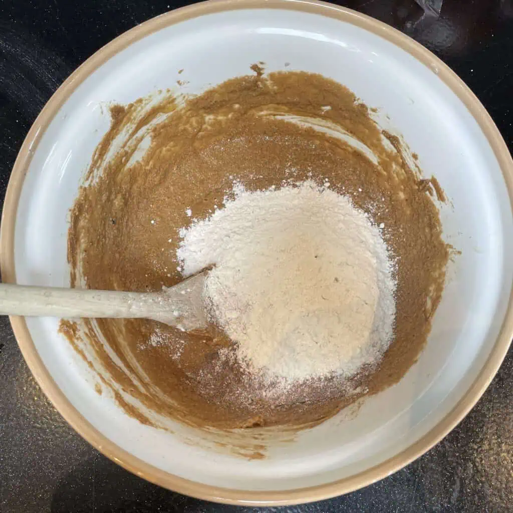 Step four for making apple loaf cake: add the flour and cinnamon and fold in