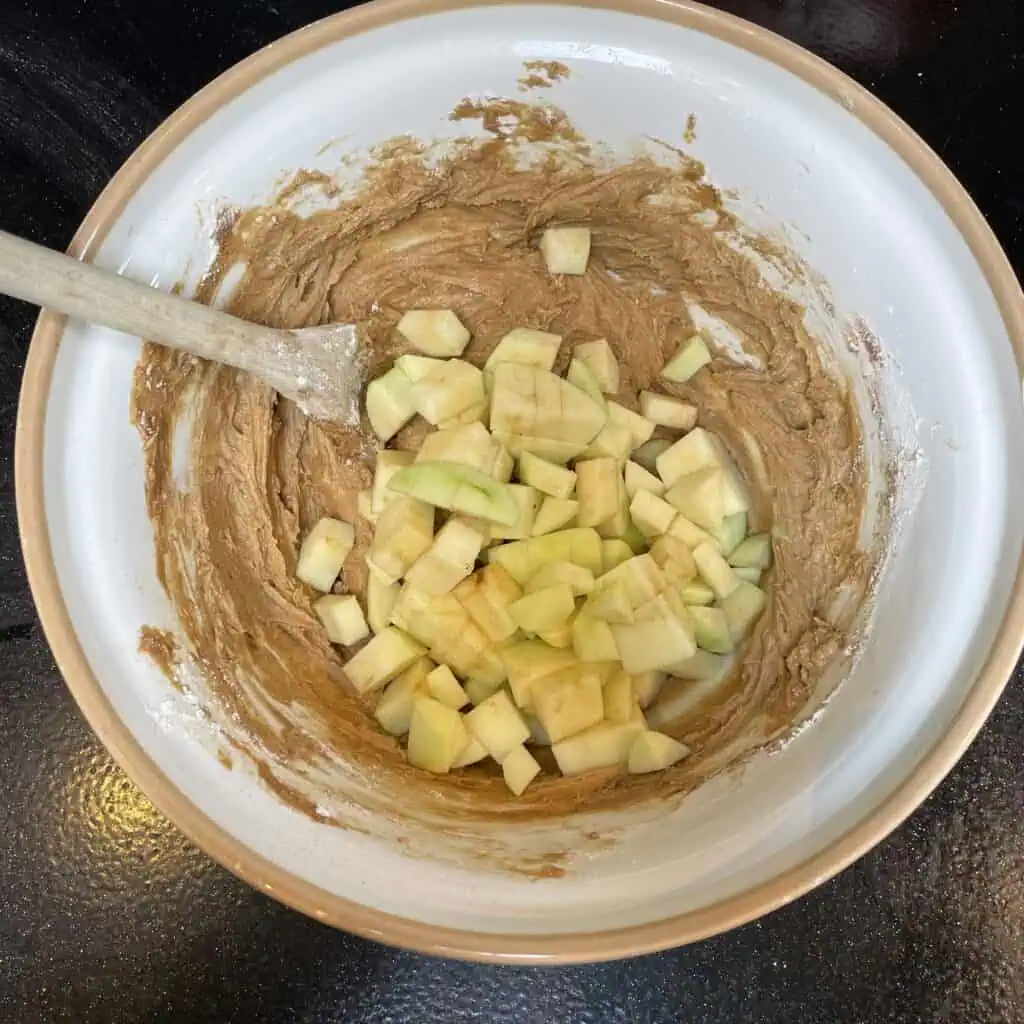 Step five for making apple loaf cake: add the apple pieces, mix
