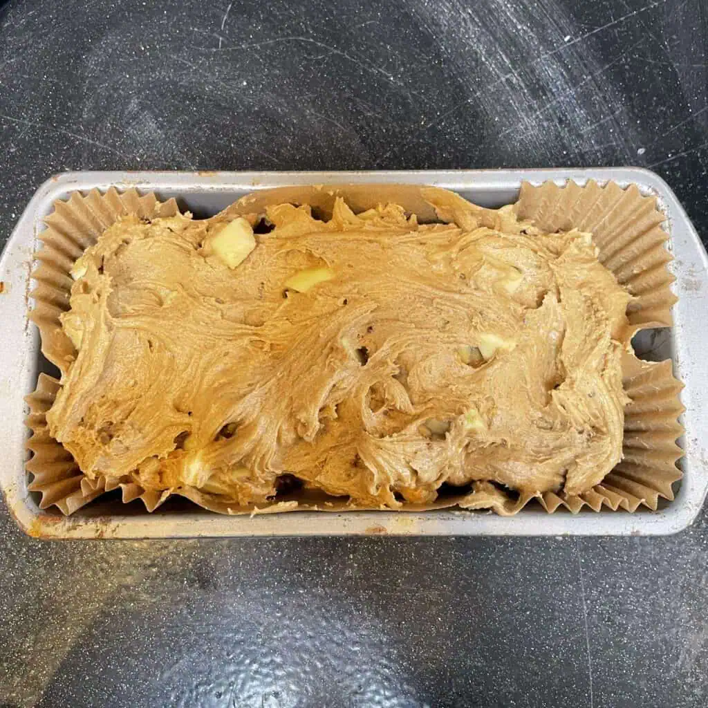 Step six for making apple loaf cake: spoon into a loaf tin and cook for one hour