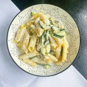 Creamy courgette pasta In a black and white bowl top view
