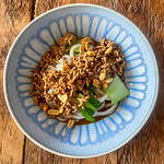 Easy pork Dan Dan noodles In a blue bowl on a wooden table