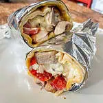 Breakfast burrito with egg and cheese, wrapped in foil on a white plate