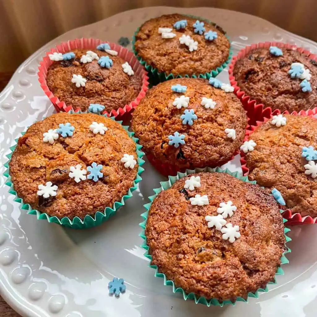 Homemade Christmas muffins decorated with sugar snowflakes in green and red muffin cases