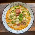 gnocchi in a creamy chorizo sauce with peas in a white bowl
