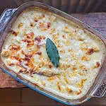 The best cauliflower cheese In a glass dish on a wooden table