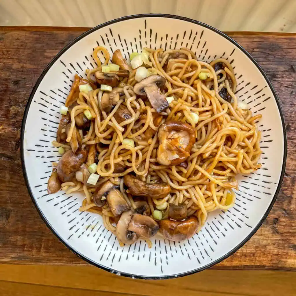 Vegan mushroom and ginger stir fry In a white bowl on a wooden table