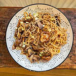 Vegan mushroom and ginger stir fry In a white bowl on a wooden table