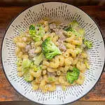 sausage and broccoli pasta in a white bowl