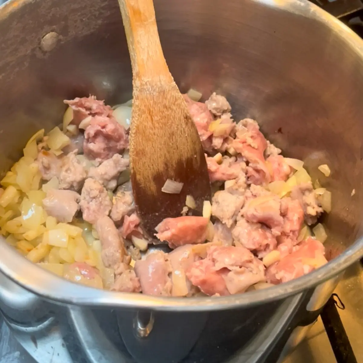 adding the sausage meat to the pan and cooking