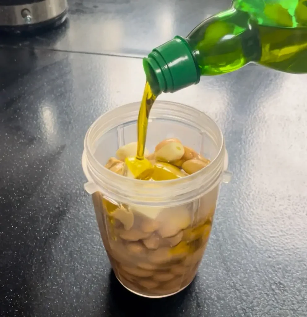 Adding white bean hummus ingredients to a blender