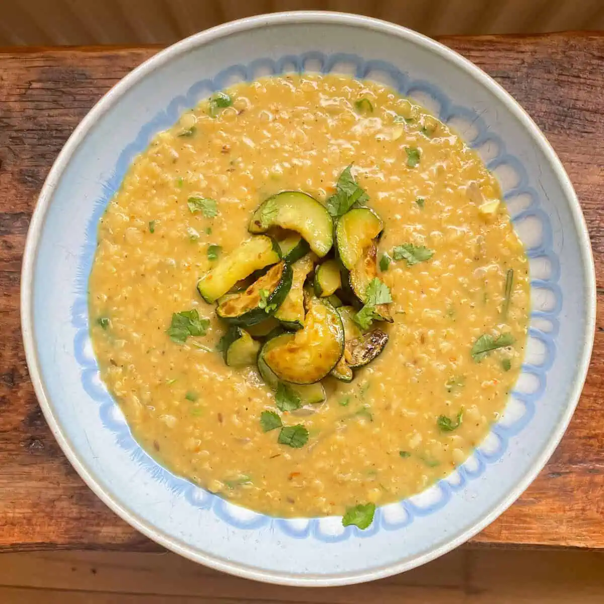 Coconut and lentil dal with red lentils topped with fried courgettes