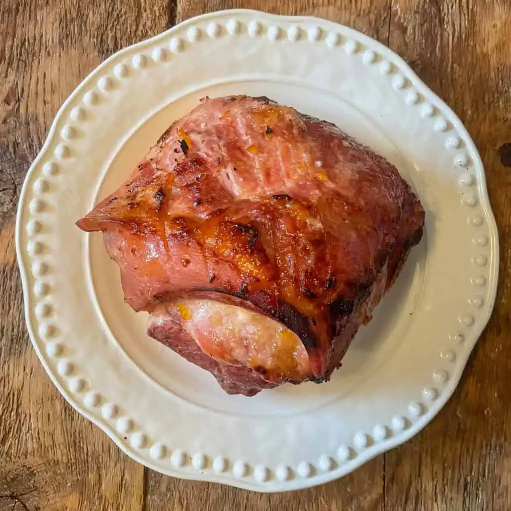 whole baked ham on a white plate