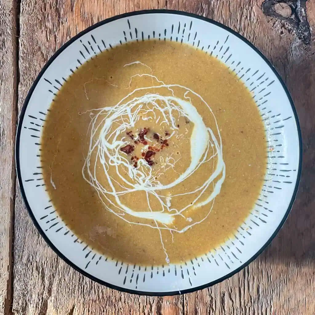 Easy 5 ingredient leek and chorizo soup in a white bowl on a wooden table