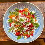 quinoa feta and roasted red pepper salad in a blue bowl